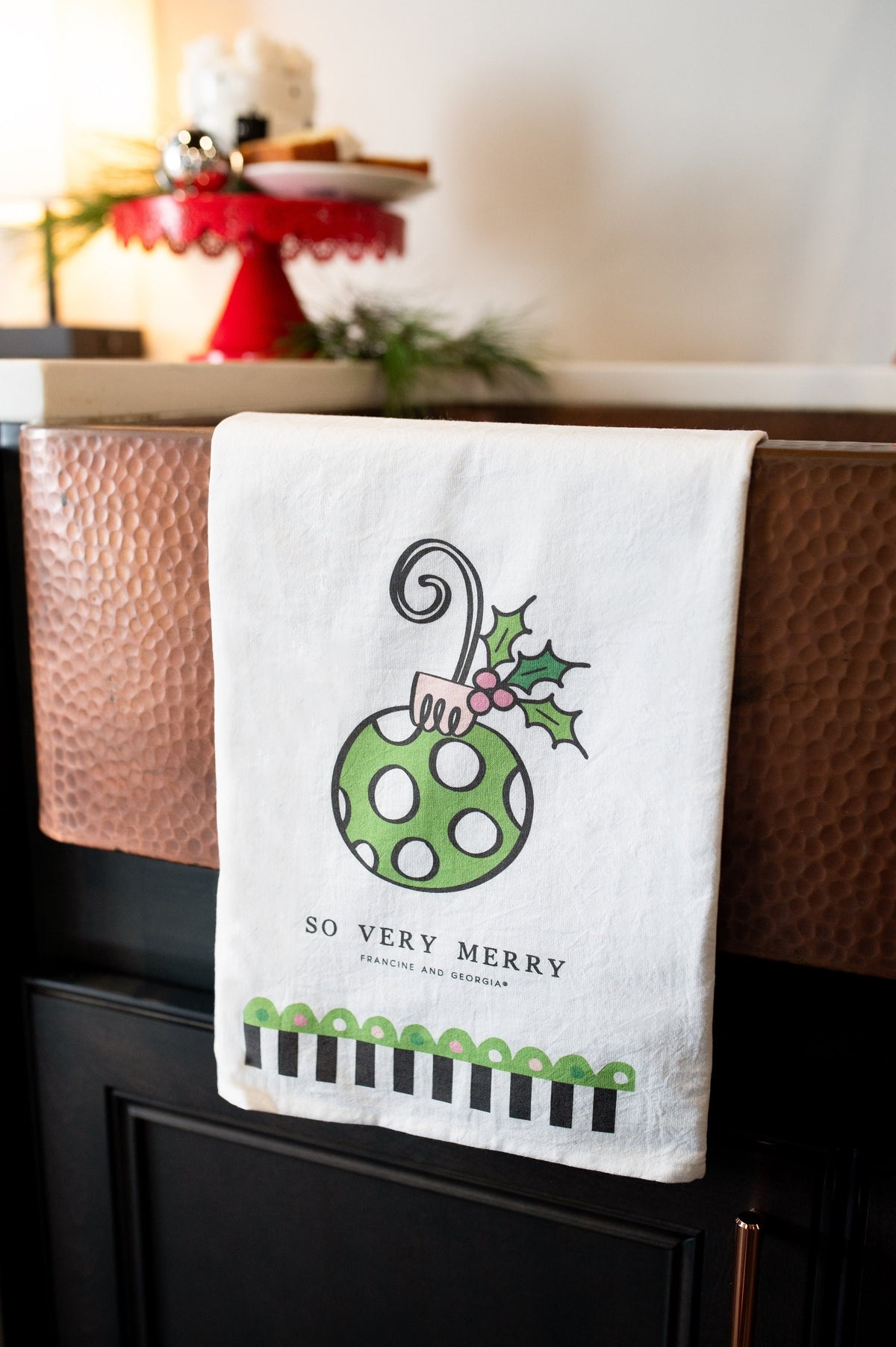 A white tea towel with a Christmas theme.
